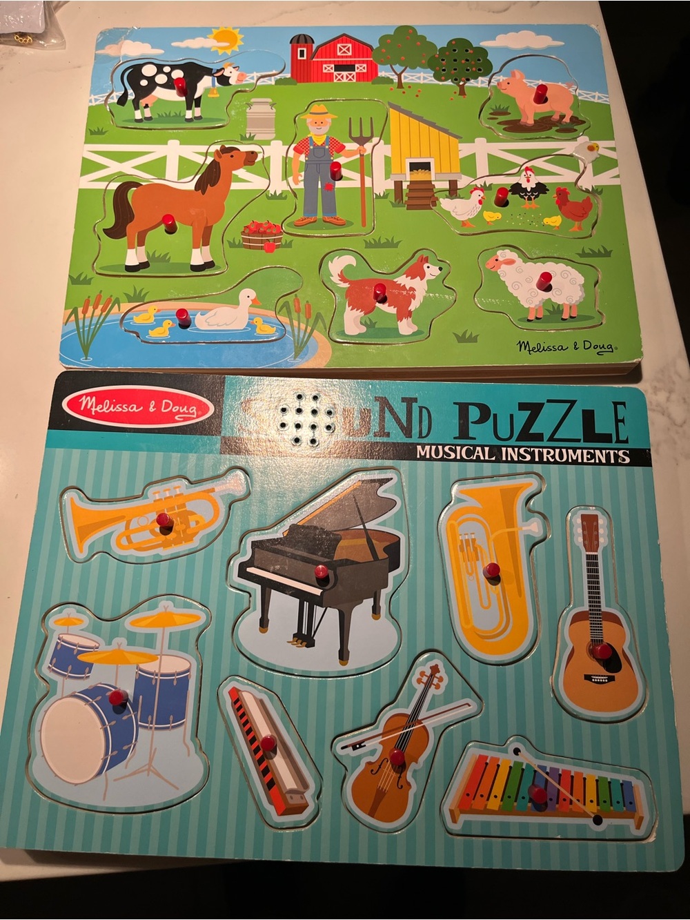 Two wooden Melissa & Doug puzzles with sound.  Both play old macdonalds farm.